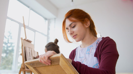 Young female woman in front of artist draws sketches of woman figure