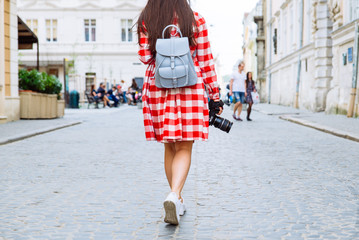 woman walking by city with camera in her hand
