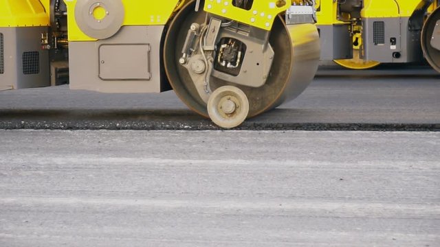 Road re-construction. Road rollers stacking hot asphalt.