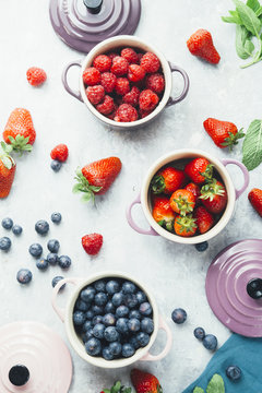 Summer fruit background, top view of berries , smoothie ingredient, inside ceramic colored cocotte, blueberries, strawberries, raspberries, flat lay