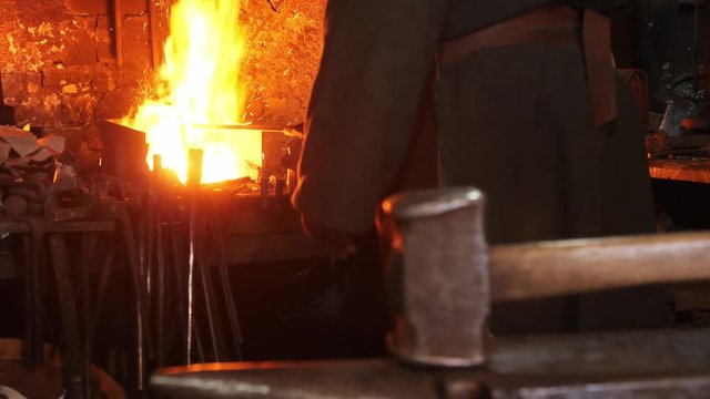 Close-up of a hammer against the background of a blacksmith working near a bugle