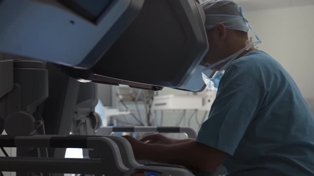 Surgeon operating medical robotic surgery machine.