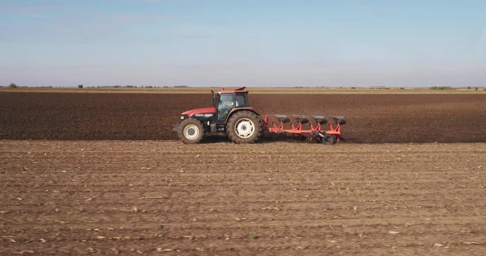 Aerial shot of a farmer plowing stubble field
