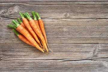 Organic food. Red carrots in the on old wooden background. Top view, copy space. Harvest