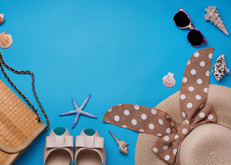 Straw hat, sunglasses and shoes on blue background