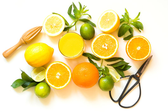 Tropical fruits for making juice of lemon, orange,lime by wooden juicer on white. Top view.