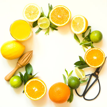 Tropical fruits for making juice of lemon, orange,lime by wooden juicer on white background. Top view. Copy space.