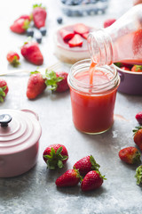 Frontal view of strawberry detox juice in w berries inside ceramic colored cocotte, blueberries, strawberries, raspberries, flat lay.Detox and healthy food concept.