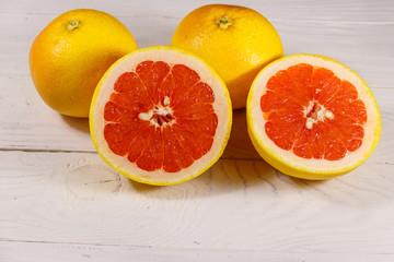 Ripe fresh grapefruits on white wooden table
