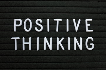 The words Positive Thinking in white plastic letters on a black letter board as a reminder to adopt a positive mental attitude for success