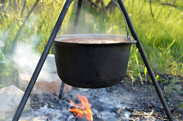 Pot hangs over the fire with preparing food