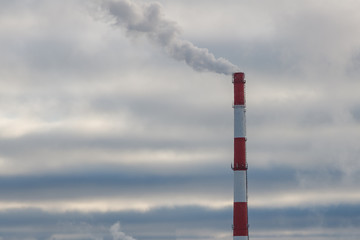 smoke from the pipe at the factory on the background of dark clouds
