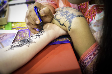 Henna tattoo application on a woman's hand