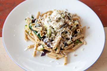 white plate with pasta, spinach and cheese