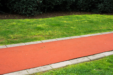 beautiful red street on the green grass background