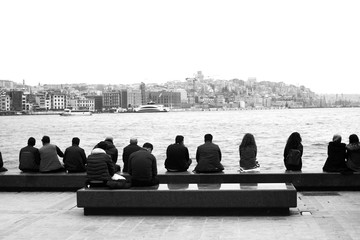 people seating on the pier near the sea