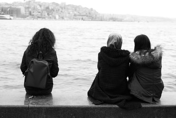 people seating on the pier near the sea