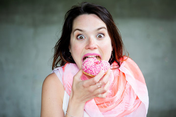 young brunette woman eating a donut