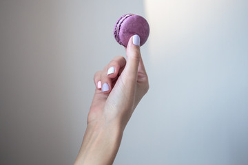 woman holds macaroons in her hands. Close up macro photo of colorful biscuits. Manicure, nail art