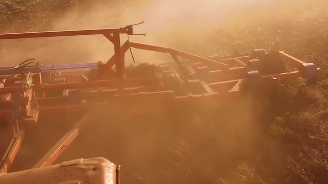 Farmer in tractor plows steadicam slow motion Russia agriculture soil the ground preparing land with seedbed cultivator as part of pre seeding activities in early spring season of lifestyle