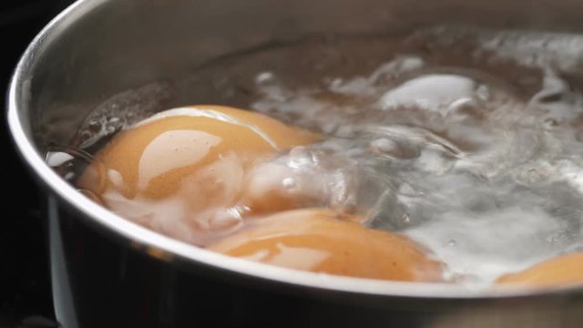 Chicken eggs boiling in stainless steel pan