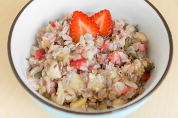Bowl of healthy oatmeal with fresh strawberries for breakfast