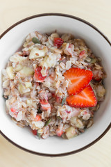 Bowl of healthy oatmeal with fresh strawberries for breakfast