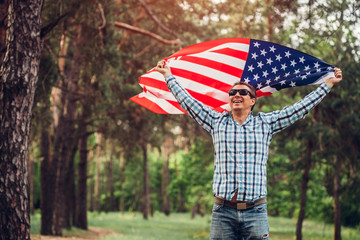 Happy man running with USA flag. Celebrating Independence Day of America. July 4th. Man having fun