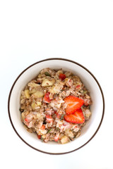 Bowl of healthy oatmeal with fresh strawberries for breakfast. Overhead shot.