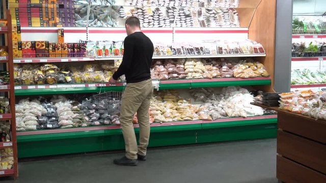 Dried fruits and nuts for sale. Man chooses products