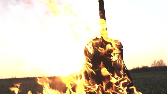 Burning acoustic guitar on fire close up