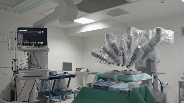 Operating room, medical surgical robot, cancerous tumor removal surgery. Modern medical equipment. Minimally Invasive Robotic Surgery with Surgical System. Helth-control monitor in background
