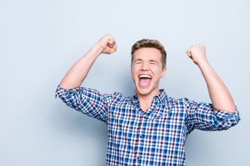 Exams pass lottery people weekend business stylish party bachelor holidays fortune concept. Portrait of excited astonished amazed rejoicing shouting person raising fists up isolated on gray background