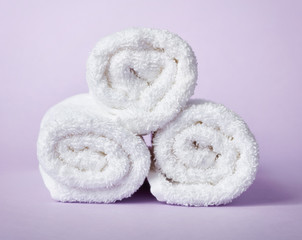 Fototapeta na wymiar White spa towels on purple background