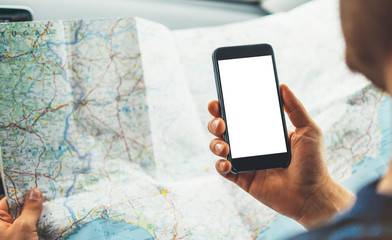 Hipster man looking on navigation map in car, tourist traveler driving and holding in male hands...