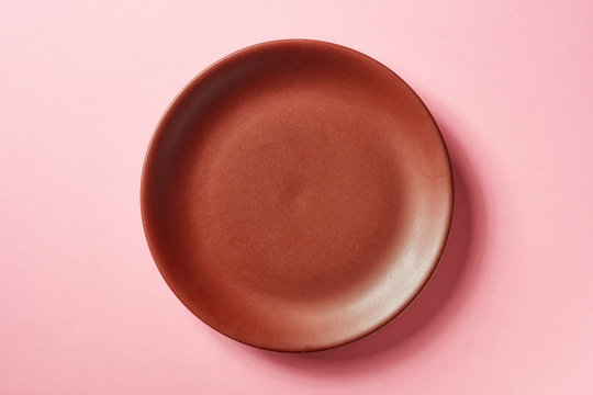Brown plate on pink background, from above
