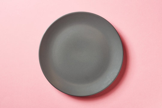 Grey plate on pink background, from above