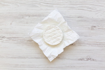 Camembert on white wooden background. Food for wine. Flatlay. Top view.