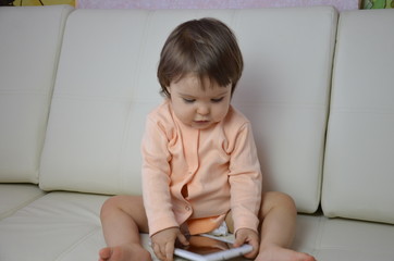 Fototapeta premium Toddler boy playing with digital tablet on couch at home