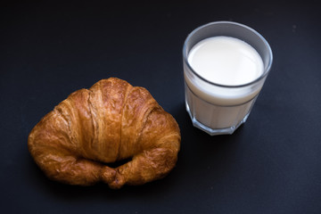 glass of milk with a croissant. Good breakfast