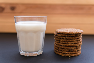 Glass cup with milk and oatmeal cookies and chocolate. healthy breakfast