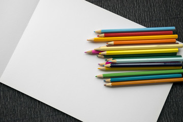 Fototapeta na wymiar Colorful pencils with blank album