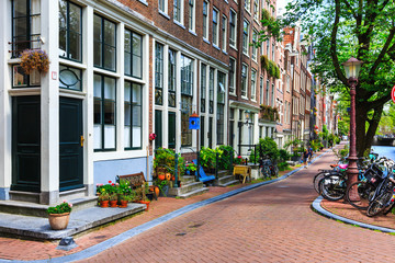 Naklejka premium Traditional dutch houses, bicycles parked on street in Amsterdam, Netherlands.