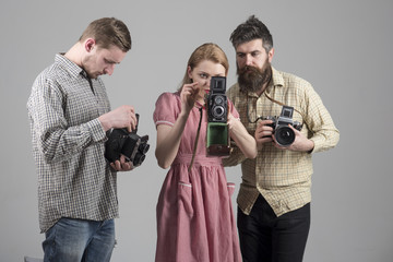 Men in checkered clothes, retro style. Company of busy photographers with old cameras, filming,...