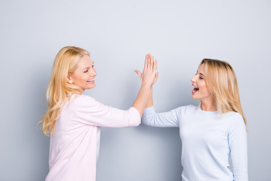 Give me high five, mother and daughter celebrating victory win, holding palms together clapping hands, winners shouting, screaming, isolated on grey background - Powered by Adobe