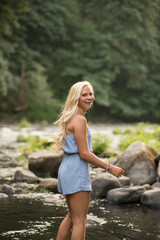 Gorgeous blonde girl laughing over shoulder at river side