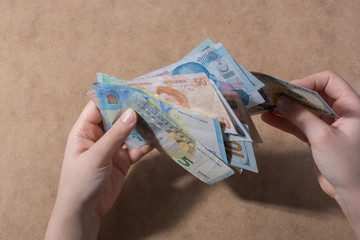 Hand holding American dollar  isolated on wooden background