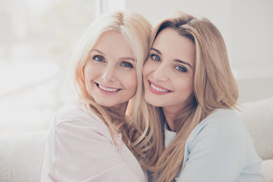 Head shot portrait of cute lovely cheerful pretty mother and daughter enjoying time together looking at camera celebrating mother day spending free time indoor