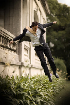 View of a young man jumping down from a balcony.