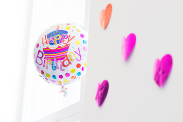 Happy birthday colorful baloon with purple hearts in white bright room